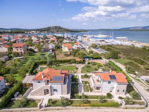 A coastal residential area with houses, a marina, and a view of the sea. - Villa Betina Wellness (Betina)