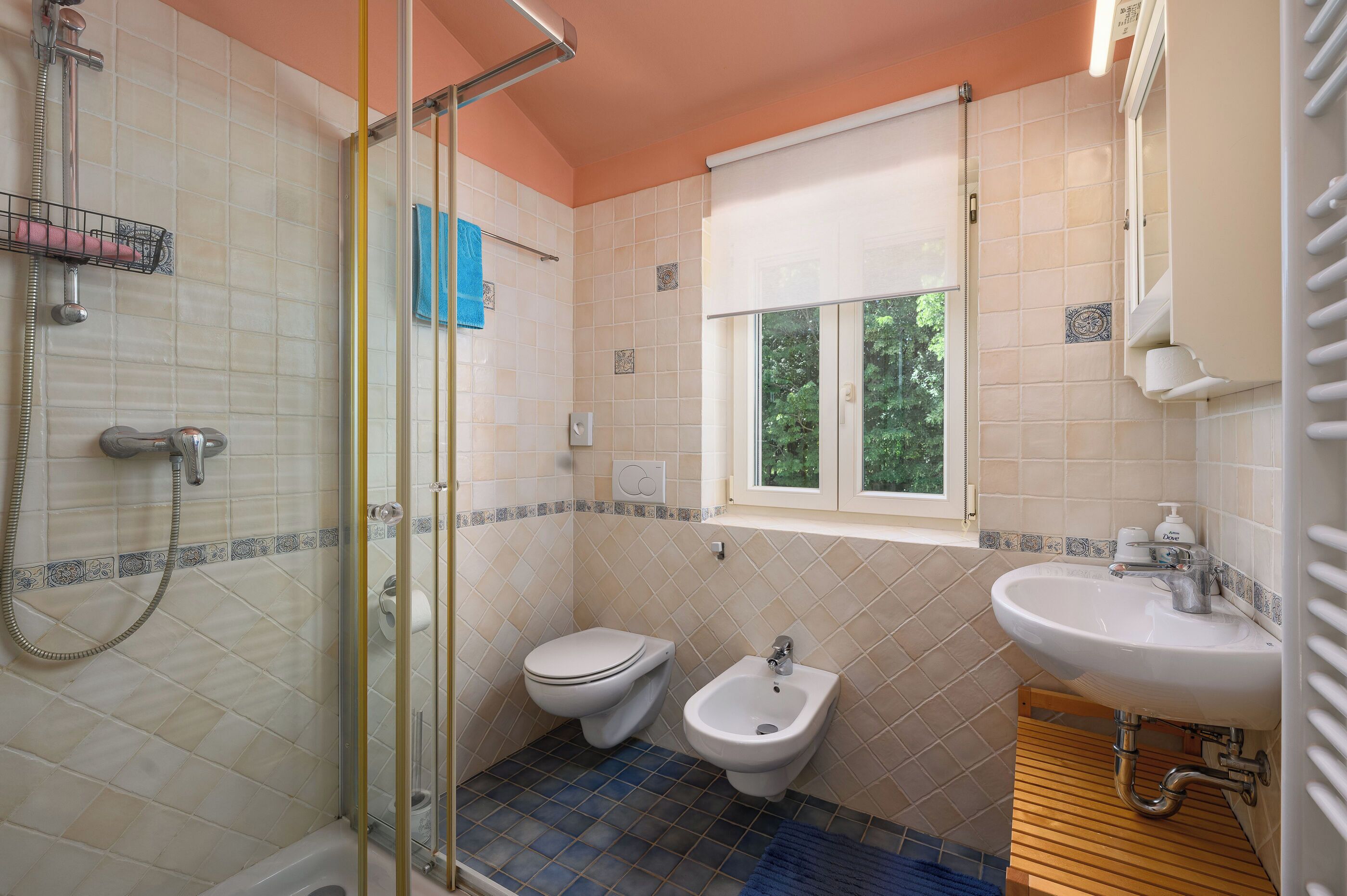 Ein Badezimmer mit Dusche, Toilette, Bidet und Waschbecken.