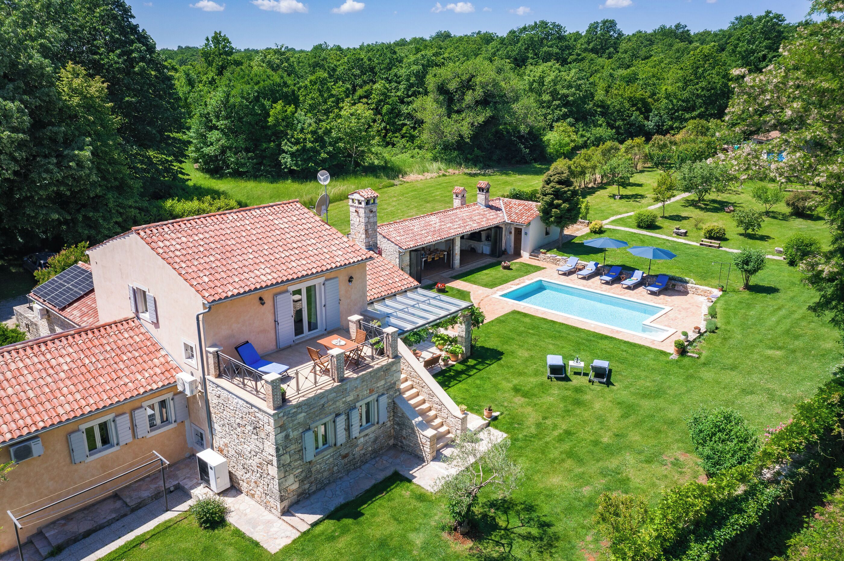 Une villa dotée d’une piscine, d’un espace salon extérieur et d’un jardin luxuriant.