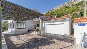 Una propiedad residencial con entrada pavimentada, terraza techada y garaje.