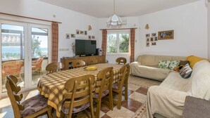 Un comedor con mesa y sillas, un sofá y una televisión.
