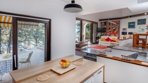 Een moderne keuken met een houten aanrecht, een schaal fruit en een koffieapparaat.