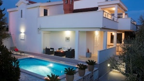 A modern two-story house with a swimming pool, outdoor seating, and a balcony. - Villa Doris (Okrug Gornji)