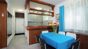 A dining area with a blue tablecloth, a vase of flowers, and wooden paneling. - Villa Doris (Okrug Gornji)