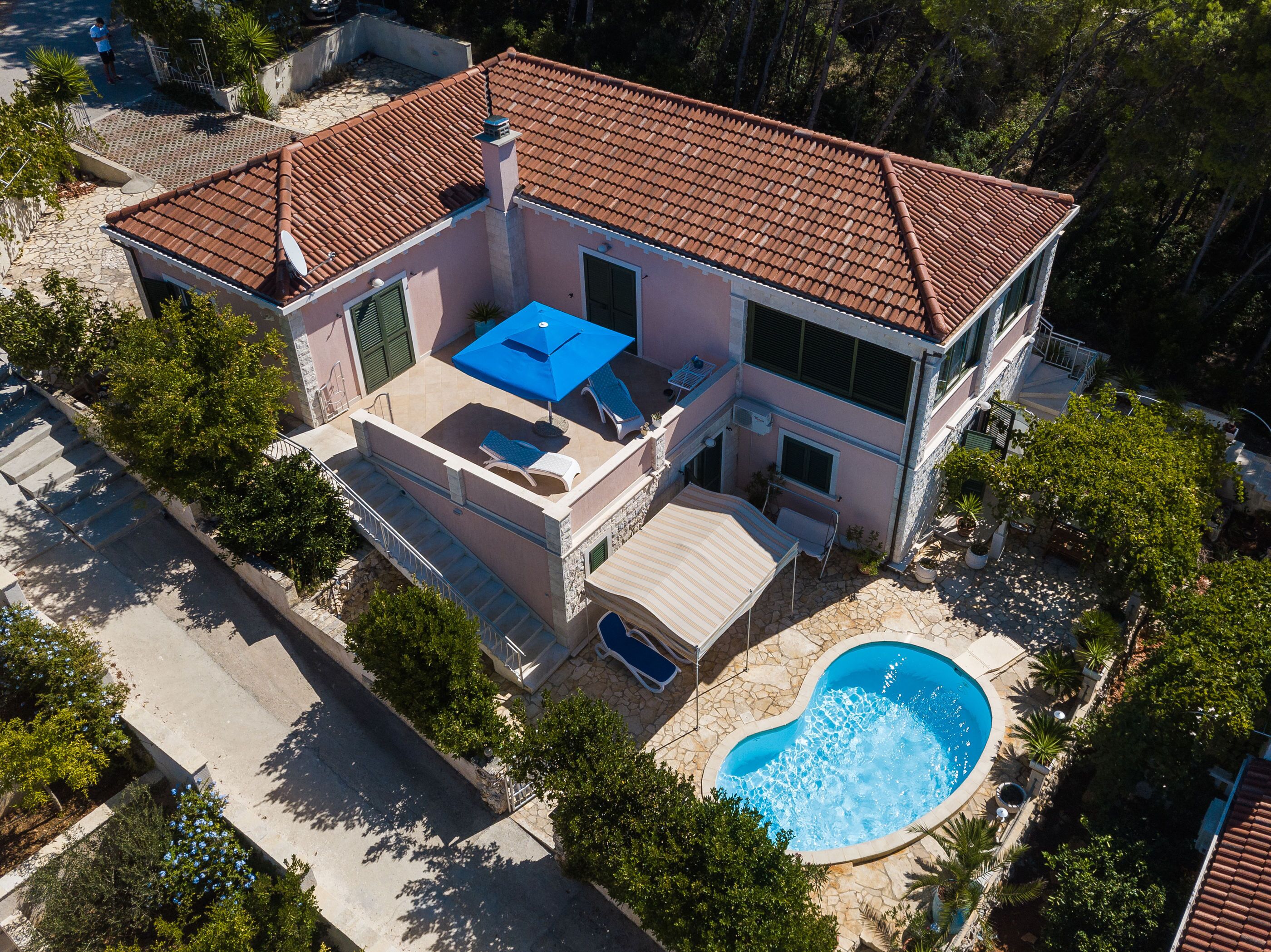Une maison à deux étages dotée d’une piscine, d’un patio couvert et d’un escalier menant à l’étage supérieur.