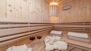 A wooden sauna with benches, towels, and glasses of red wine. - Villa Kirstin (Privlaka)