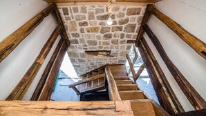 A wooden staircase with a stone ceiling and a rope light fixture. - Villa Lipa (Privlaka)