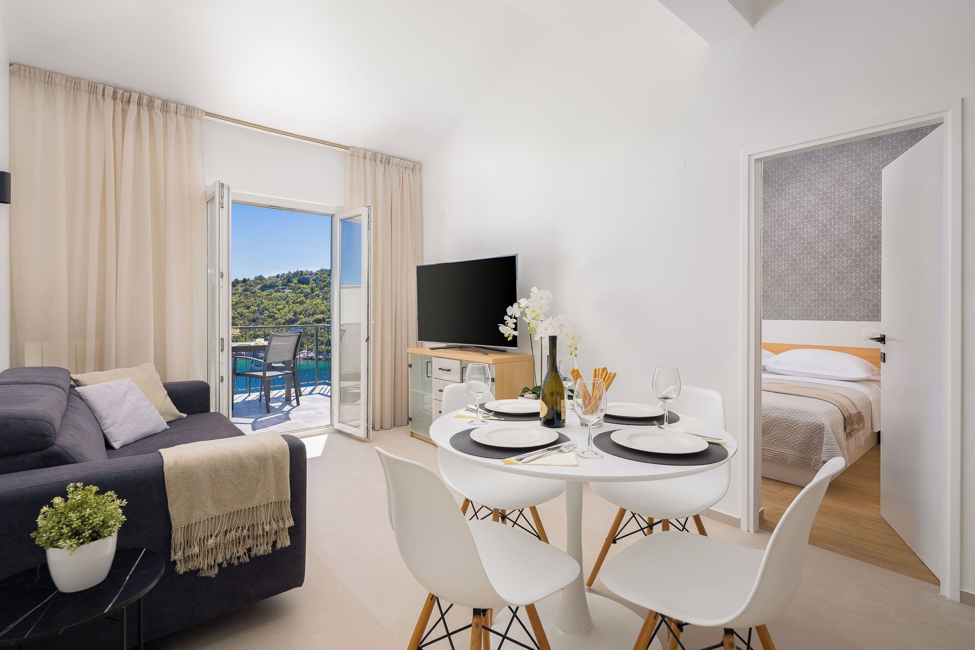 Une chambre d’hôtel moderne dotée d’un balcon, d’un coin repas et d’un lit.