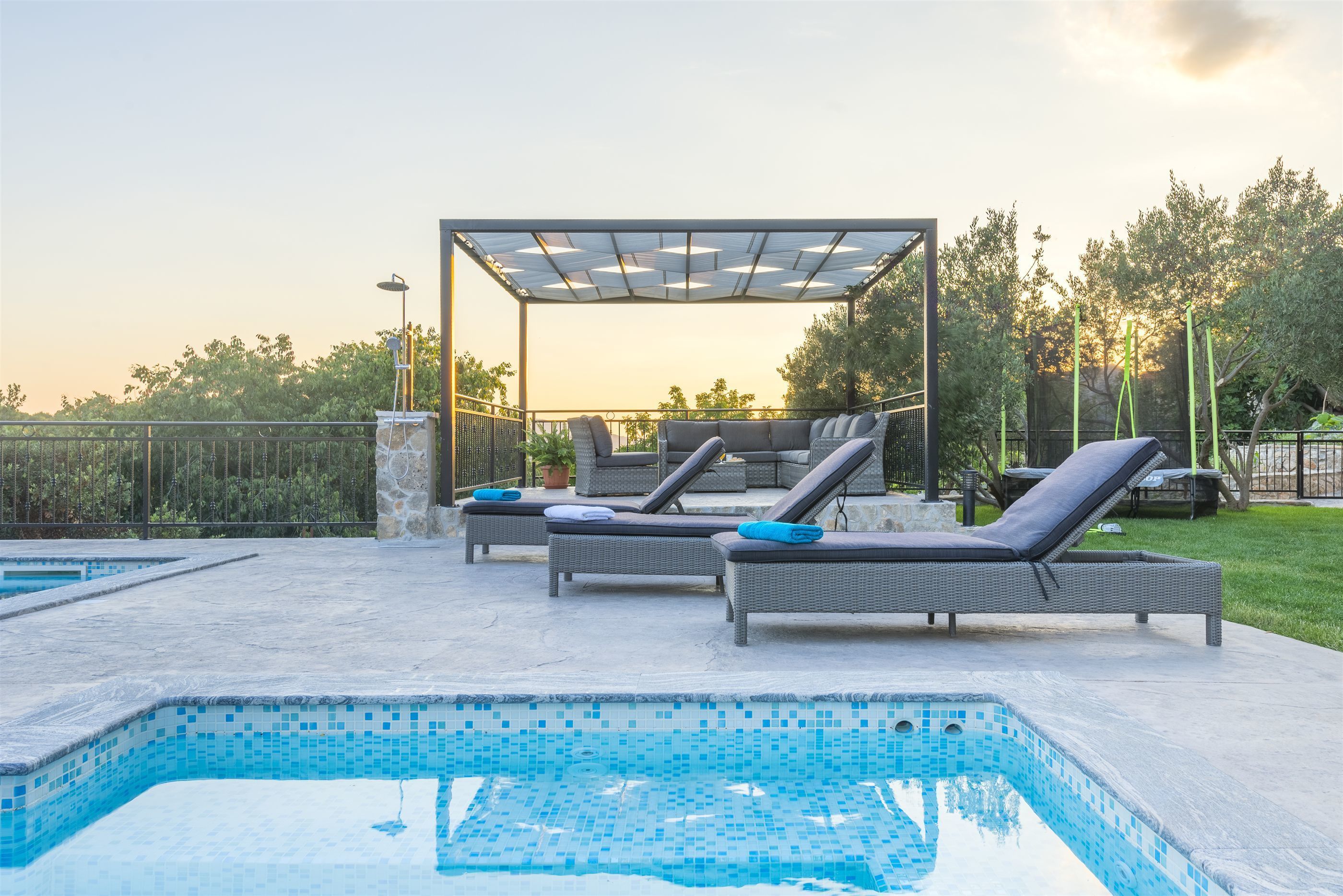 Ein Schwimmbecken mit Liegestühlen und einer Pergola.