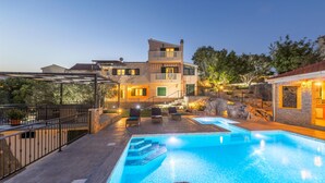 Un hotel moderno con piscina, area relax all'aperto e terrazza ben illuminata.