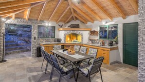 Una cucina rustica con camino in pietra, travi in legno e parete in pietra.