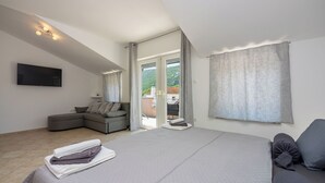 Une chambre à coucher moderne avec un grand lit, un canapé et un téléviseur.
