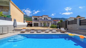 Une piscine avec des chaises longues et une vue sur une montagne.