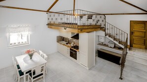 Una cocina amplia con escalera de madera y balcón.