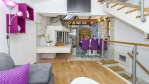 A modern interior with a staircase, a dining area, and a living space with a sofa and lamp. - Villa Strnj (Zivogosce)