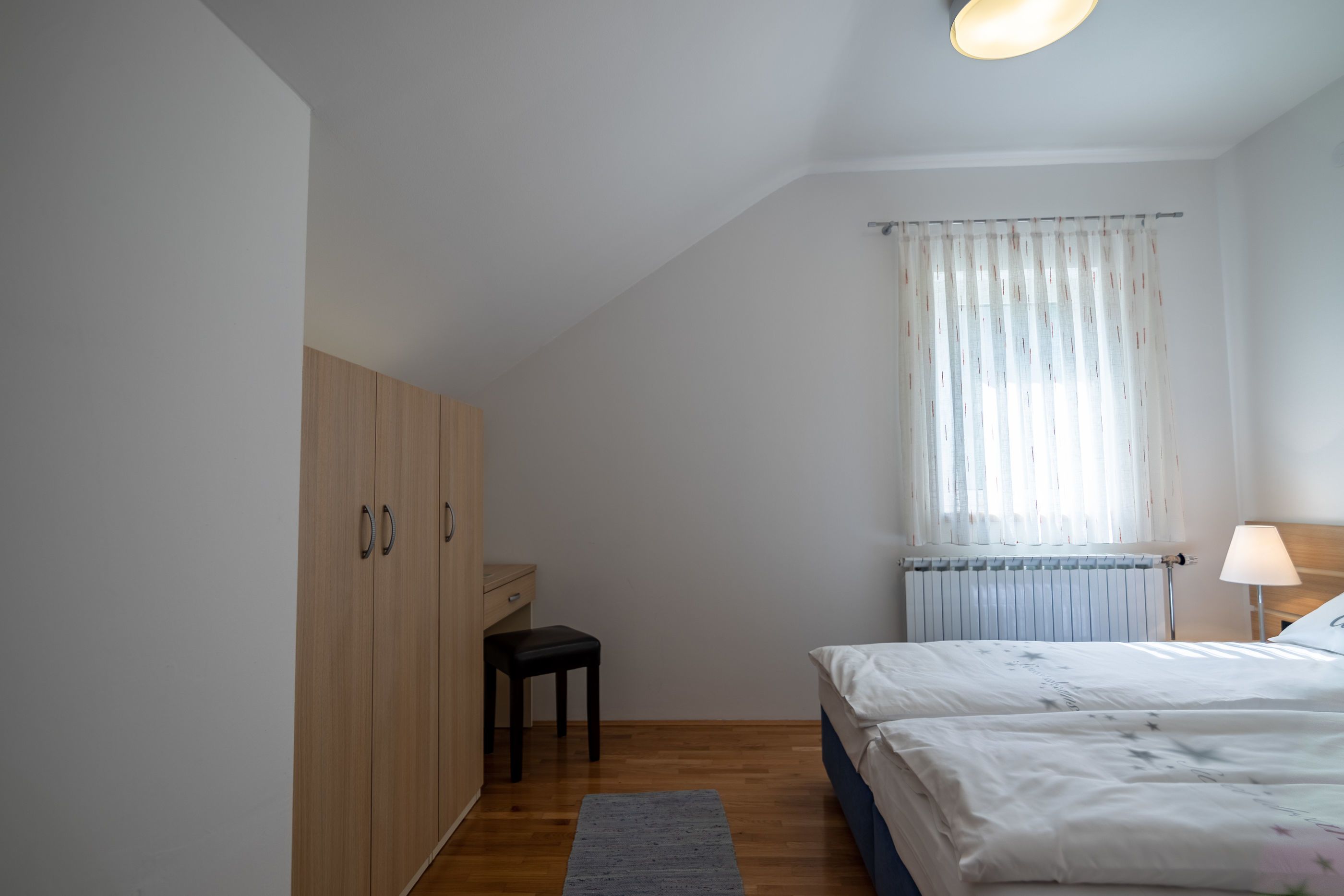 Ein Schlafzimmer mit einem Bett, einem Schreibtisch und einem Kleiderschrank.