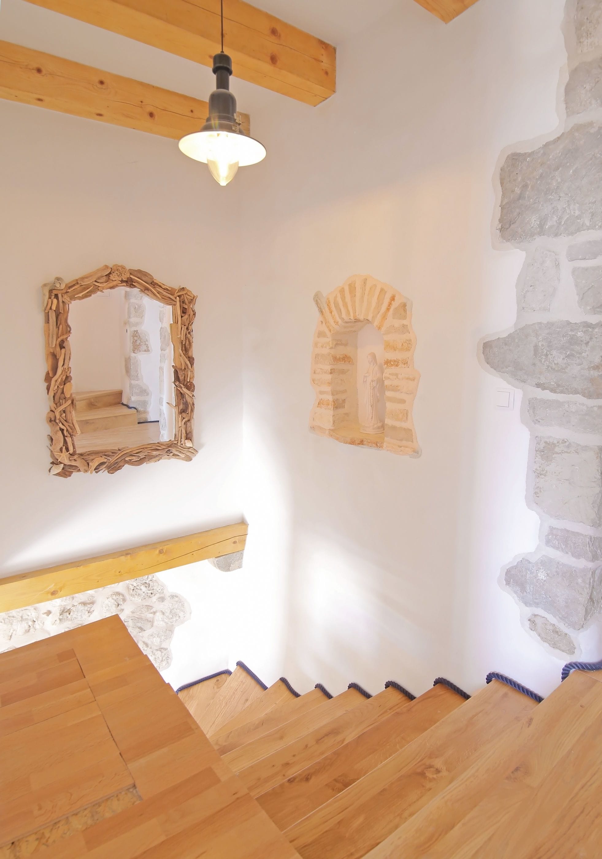 A staircase with wooden steps and a stone wall.