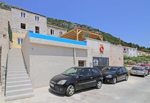 Um edifício com telhado azul, pérgula de madeira e boia na parede.