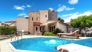 A swimming pool with lounge chairs, a stone tower, and a modern building with a red roof. - Villa Jelena Vir Near Beach (Liznjan)