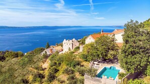 A coastal property with a swimming pool, stone buildings, and a view of the sea. - House La Casa Simone (Jesenice)