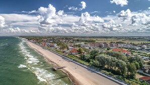 A coastal town with a beach, residential buildings, and a clear sky. - Wczasowa 8 Apartments Sarbinowo (Sarbinowo)