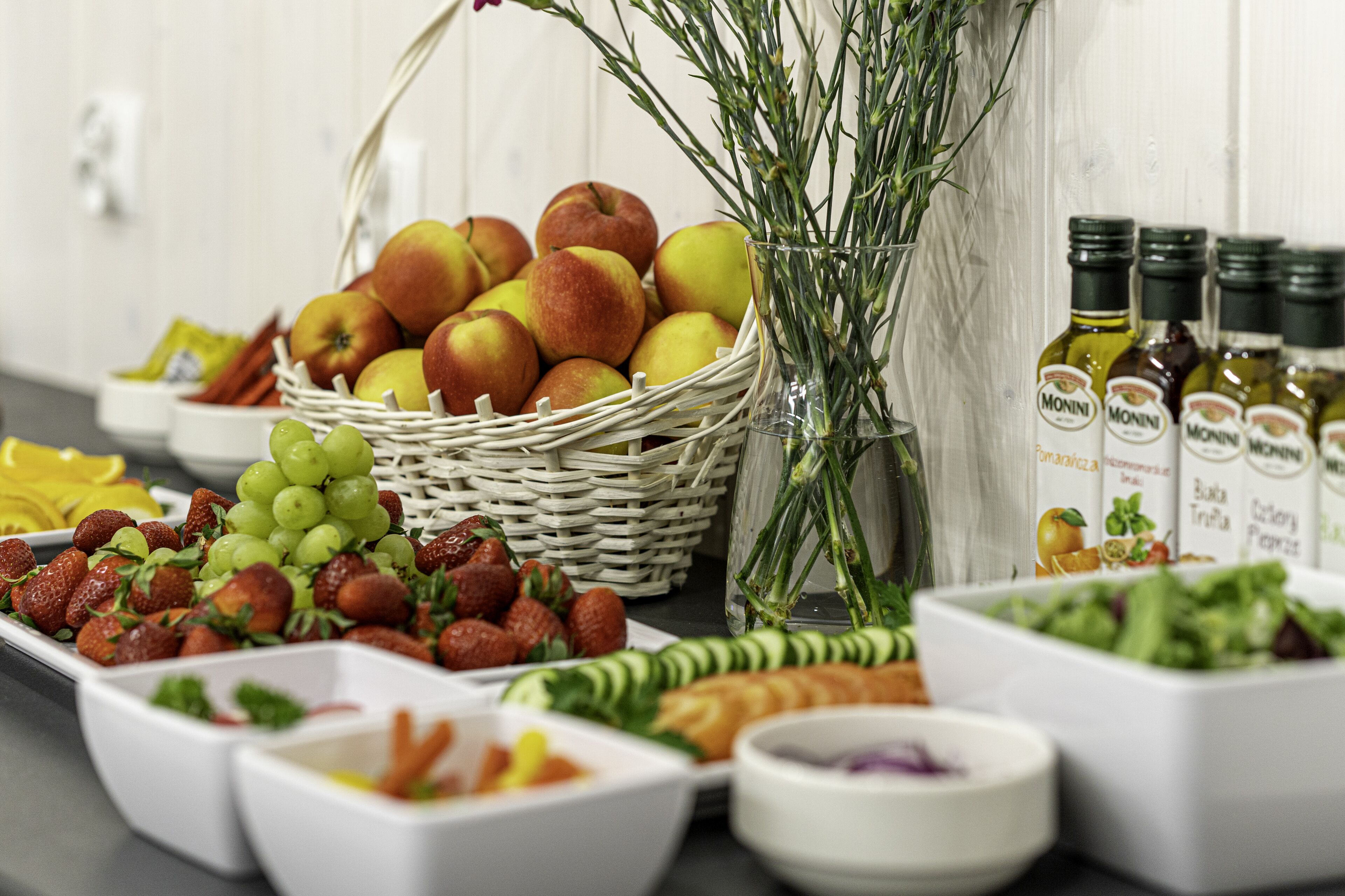 Une table de buffet proposant une variété d’aliments, notamment des fruits, des légumes et des sauces.