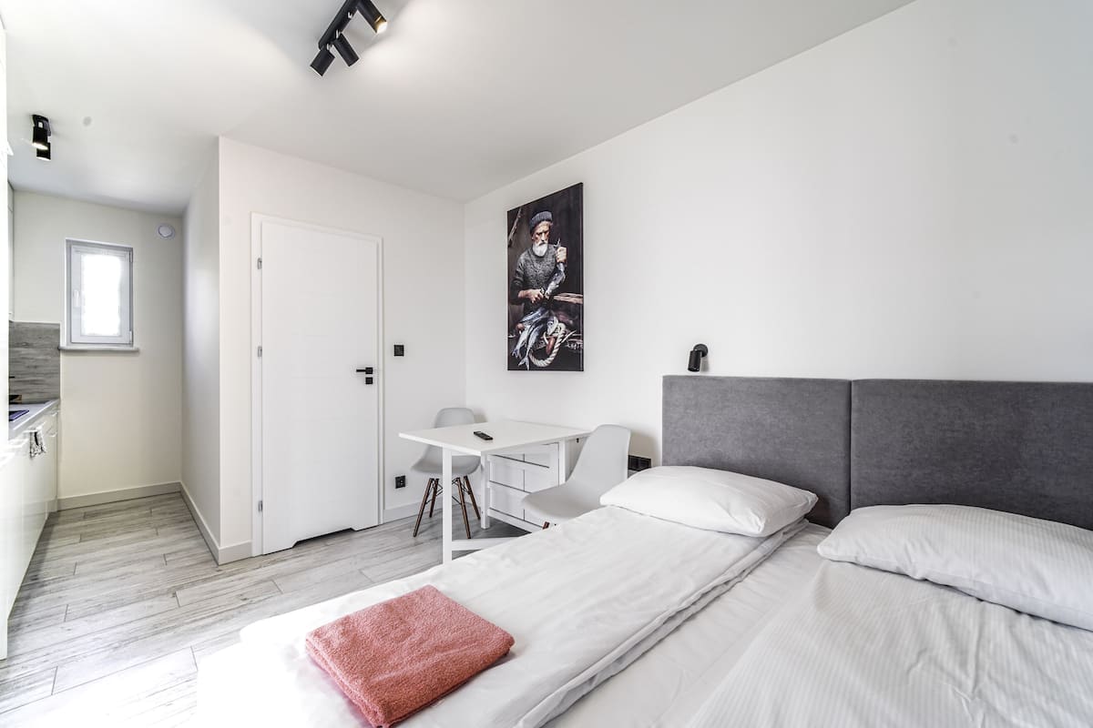 A modern hotel room with a bed, a desk, and a chair.