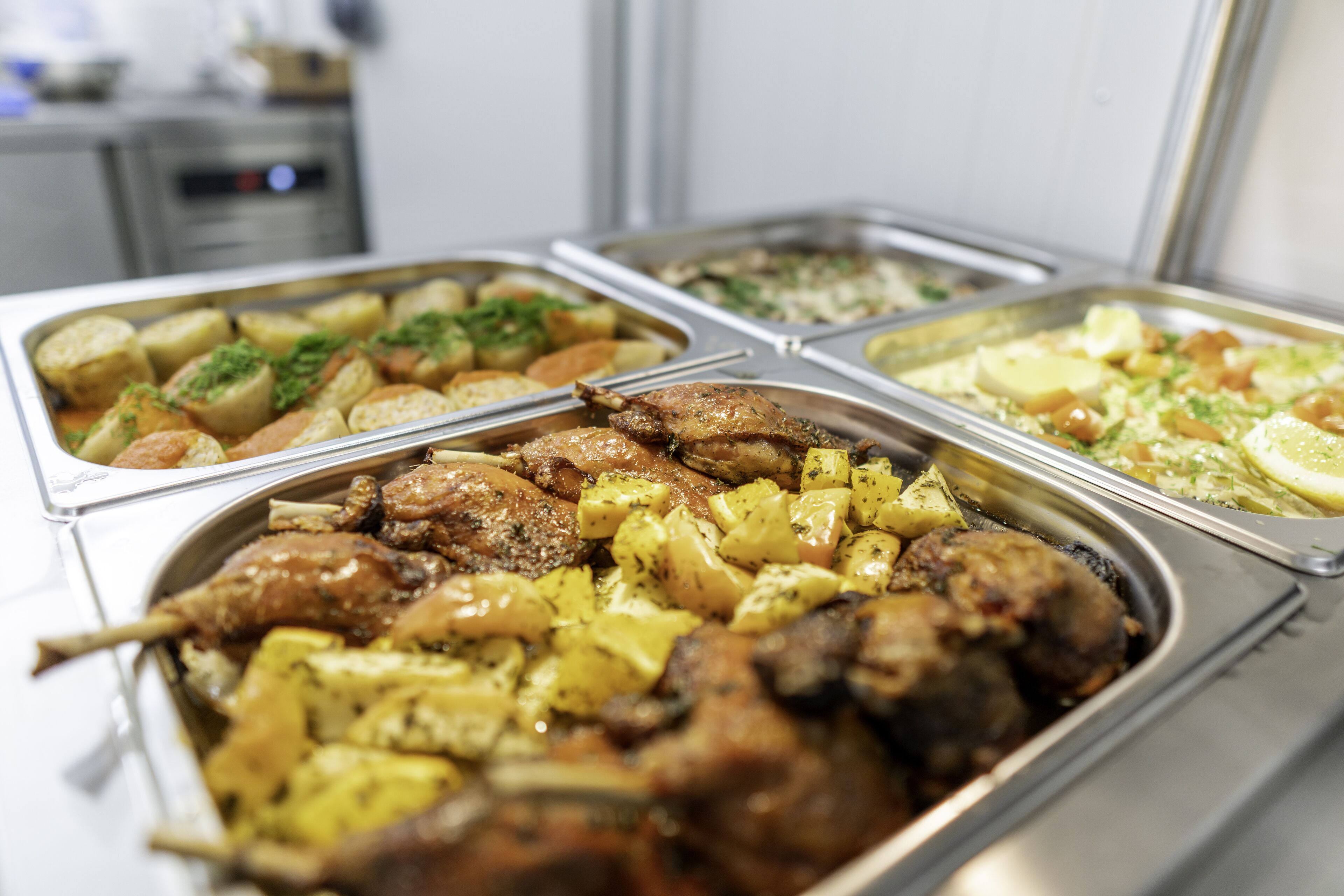 A buffet with various dishes including roasted meats, potatoes, and vegetables.