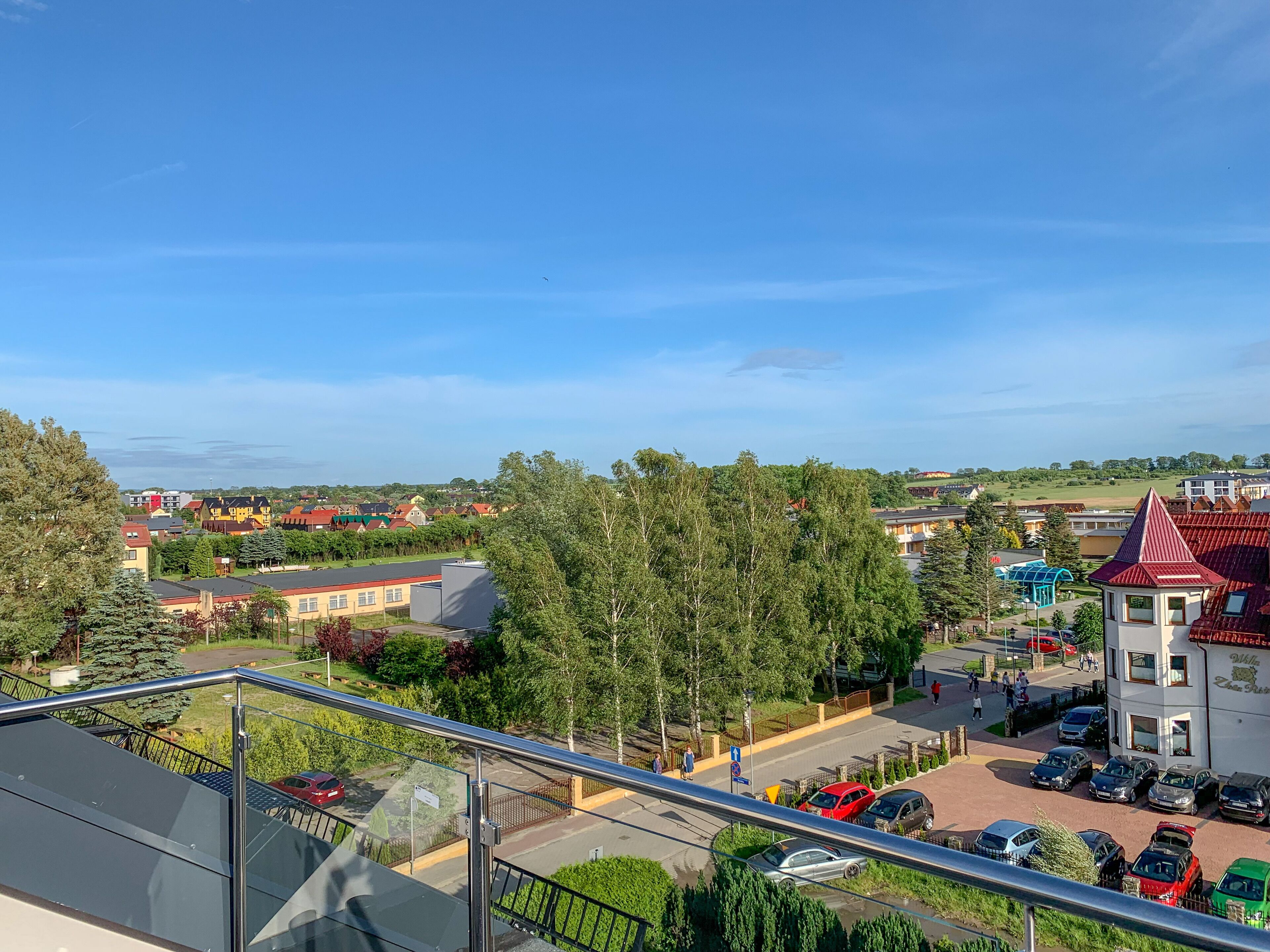 Una zona residencial con casas, un estacionamiento y un cielo azul despejado.