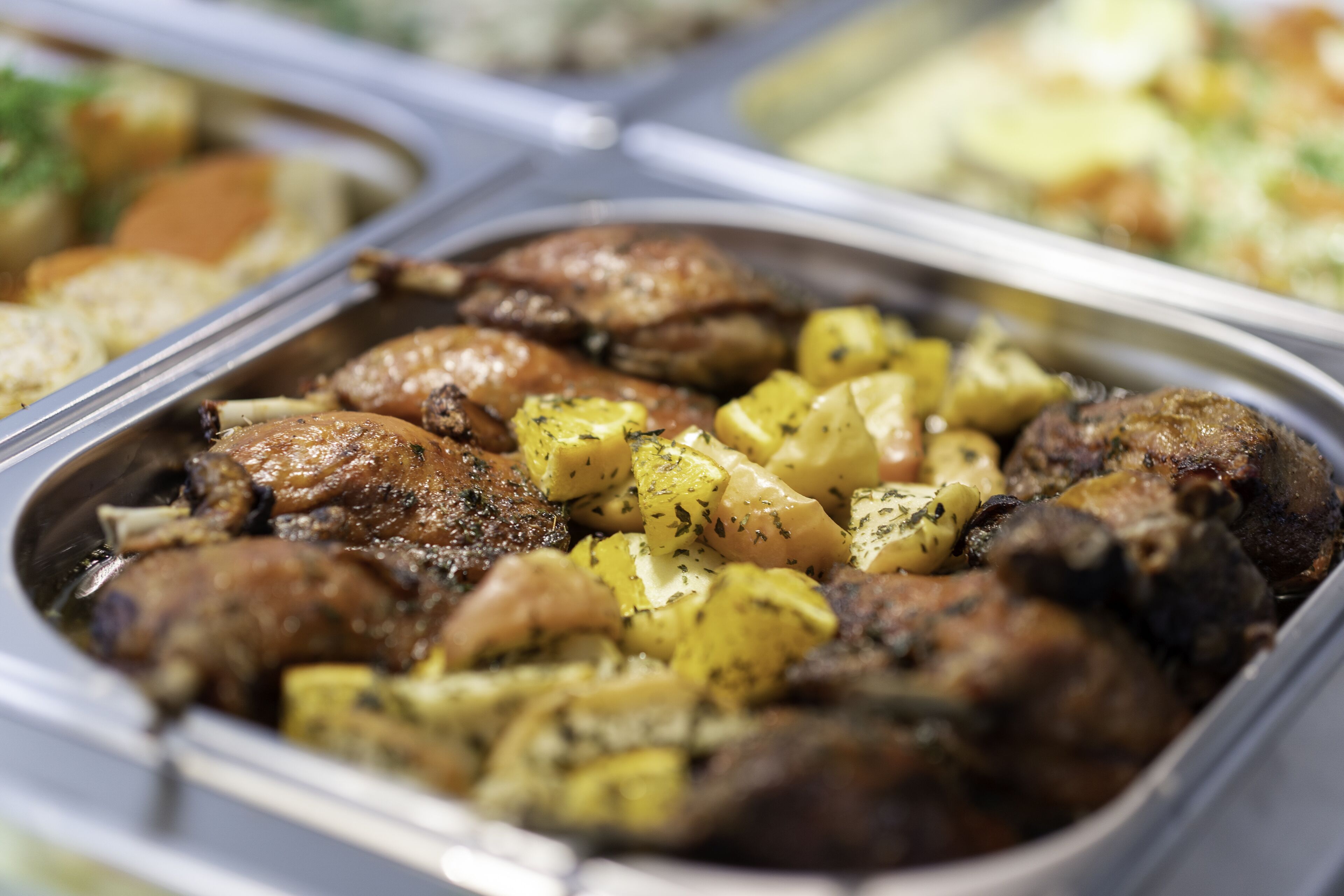 A buffet with roasted meats and potatoes.