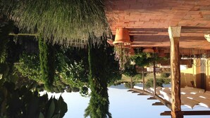 A wooden pergola with hanging terracotta pots and lush greenery. - Casa Rota (Arahuetes)