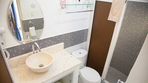 A small bathroom with a sink, toilet, and shower. - Nelson y Yadiria (Trinidad)