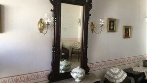 A room with a large ornate mirror, a table with a white vase, and two wall sconces. - Casa Boca 170 (Trinidad)