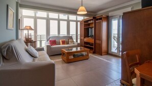 A living room with a sofa, coffee table, and wooden cabinet. - Apartamento Paseo Maritimo 27 (Cádiz)