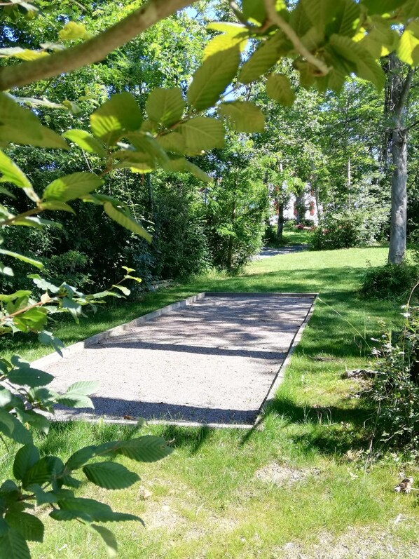 A paved pathway in a park with surrounding greenery and trees. - Domaine Abartiague B&B (Osses)