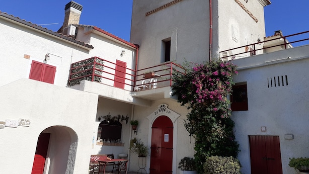 A building with a red door, a balcony with red railings, and a small window with a star-shaped window frame. - Pier delle Vigne B&B (Pineto)
