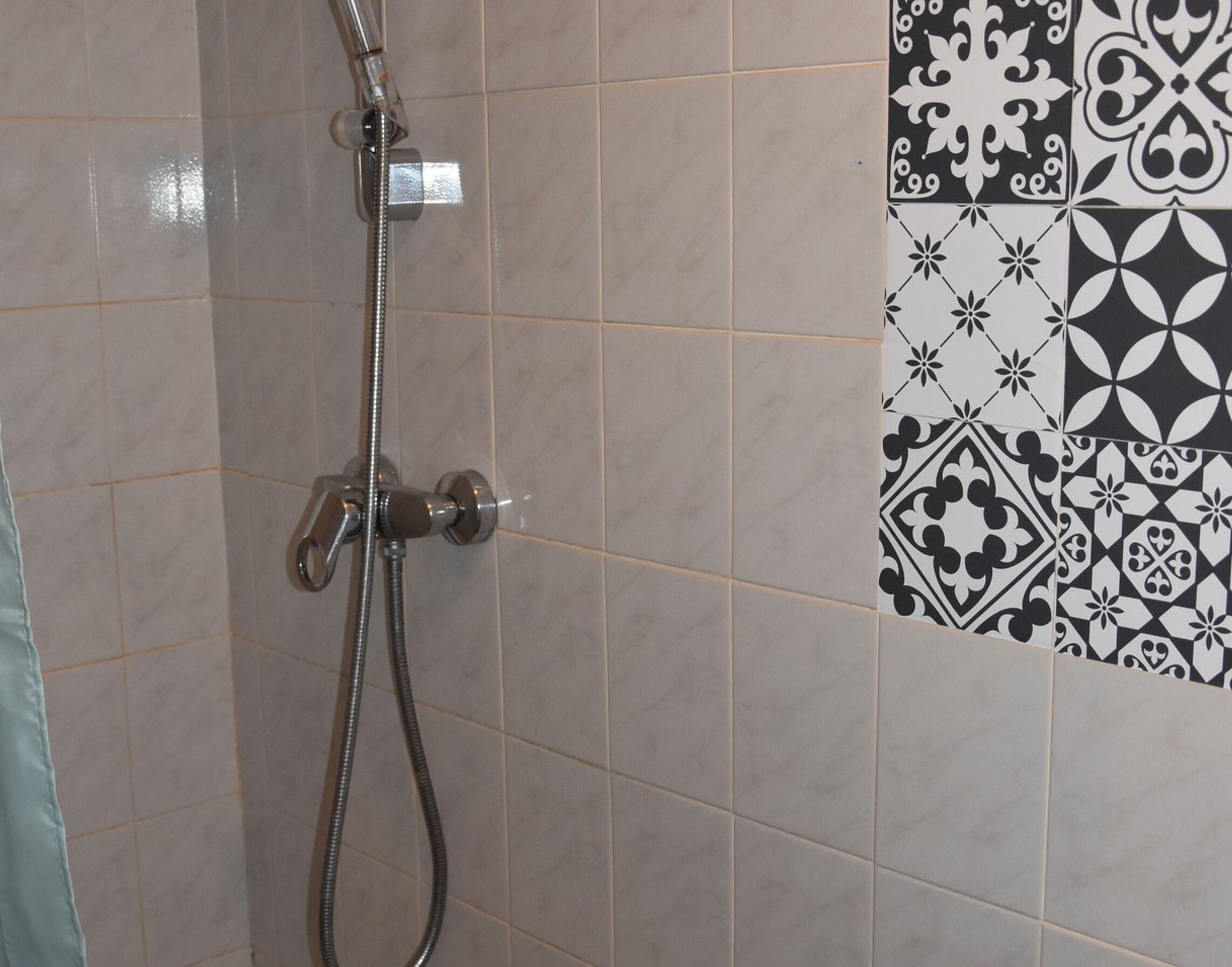 Ducha con manguera de mano y grifo empotrado.
