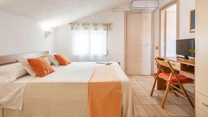 A bedroom with a bed, pillows, a desk, a chair, and a television. - Bed & Breakfast Dorgali (Dorgali)