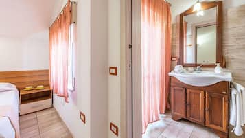 A bathroom with a wooden vanity, a mirror, and a shower curtain.