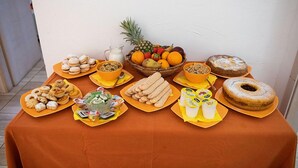 A table with various food items and a fruit basket. - Bed & Breakfast Dorgali (Dorgali)