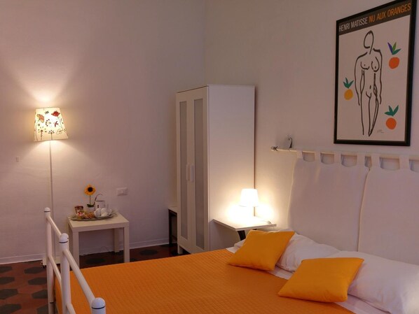 A bedroom with a bed, two bedside tables, a nightstand, a wardrobe, and a wall-mounted artwork. - Lucretia House Affittacamere (Florence)