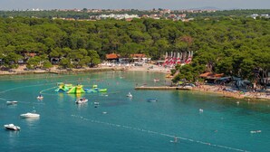 A coastal area with boats, water activities, and a beach with umbrellas. - Heritage Hotel Raznjevica Dvori (Polaca)