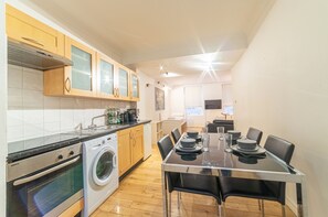 Een oven, een waterkoker, kookgerei, borden en bestek