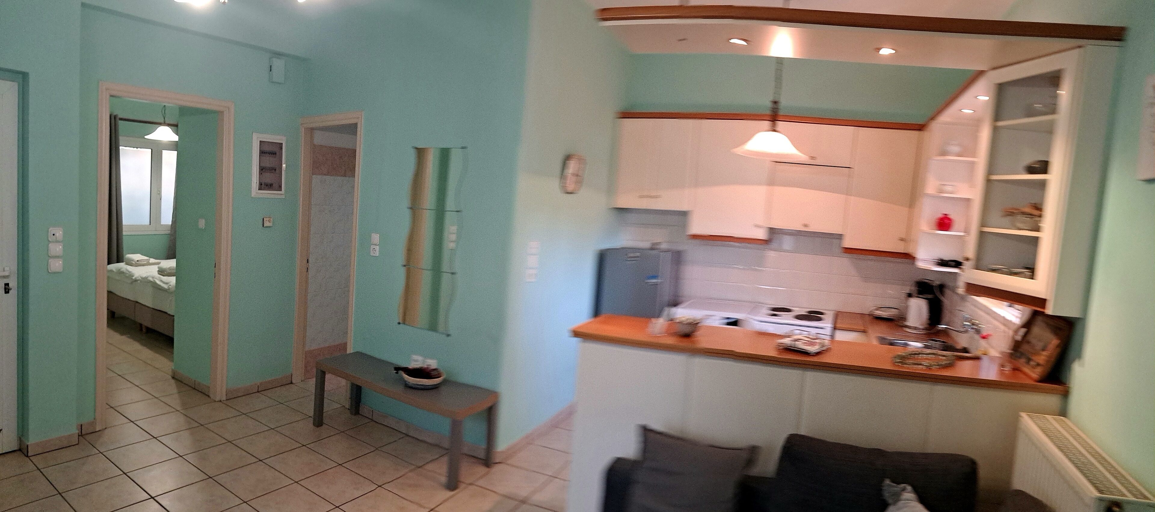 A compact kitchen with a wooden countertop, a bench, and a dining area with a sofa.
