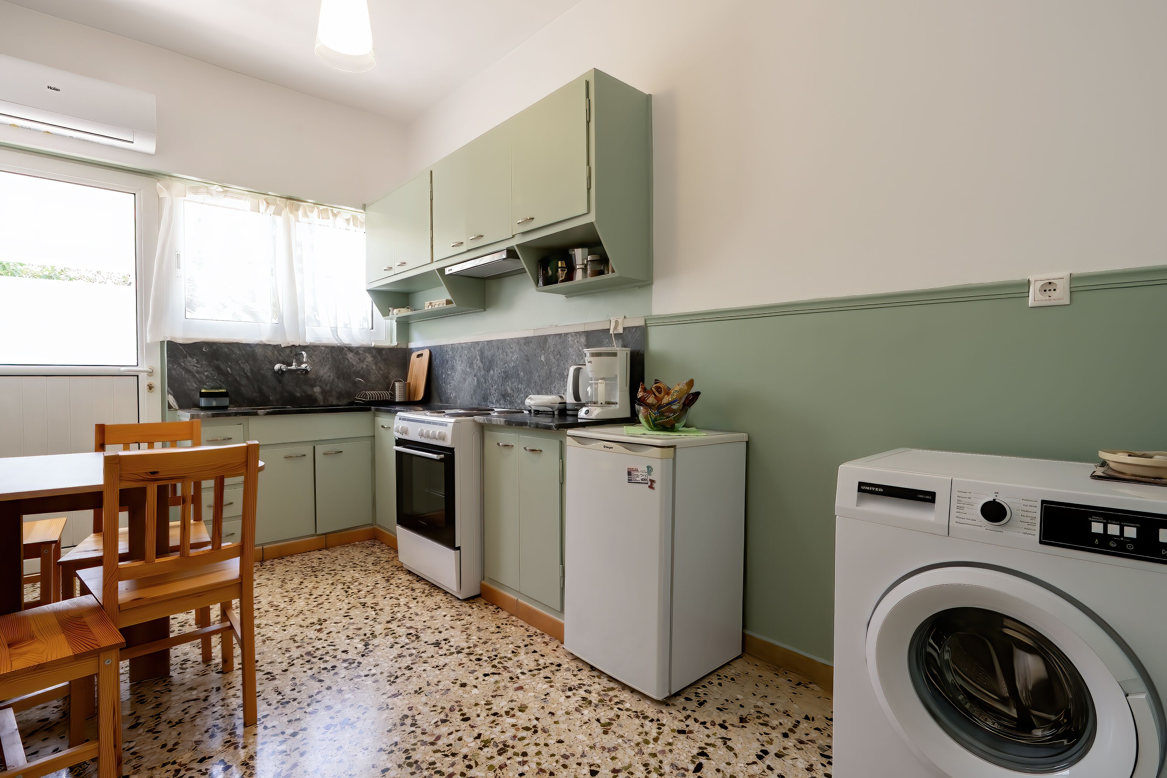 Una cocina con estufa, horno, refrigerador y lavadora.