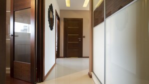 Un pasillo con una puerta de madera, un espejo y un separador de vidrio esmerilado.