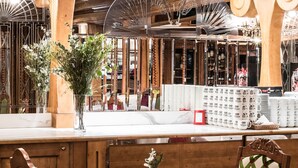 A restaurant with a wooden interior, white tablecloths, and a variety of seating options including chairs and a bench. - Aries Hotel & SPA Wisla (Wisla)