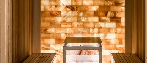 Una sauna con bancos de madera y una pared de piedra.