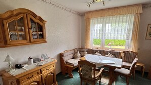 A dining area with a wooden cabinet, a table, and chairs. - Vacation home 05 Juliane - W1 (Esens)