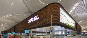 A modern hotel with a prominent sign, located in an airport terminal. - YOTEL Istanbul Airport LANDSIDE, City Entrance  (Arnavutköy)